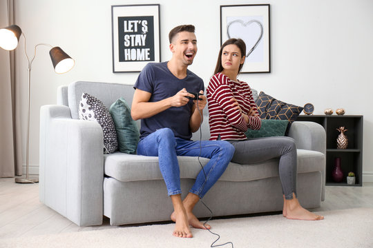 Young couple having conflict while playing video game at home