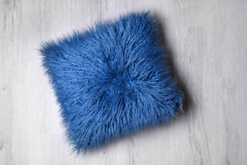 Fluffy pillow on wooden floor