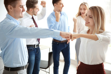 Fototapeta premium Young people in office wear celebrating success indoors. Unity concept