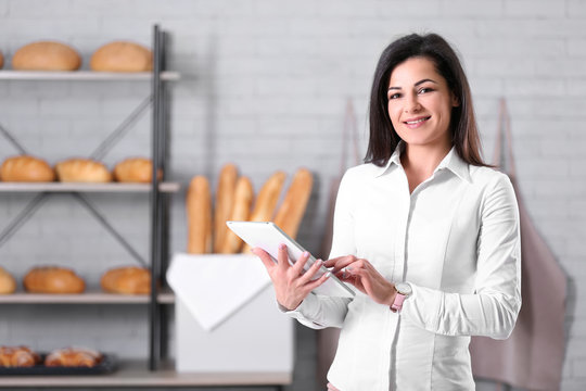 Portrait of young woman in bakery. Small business owner