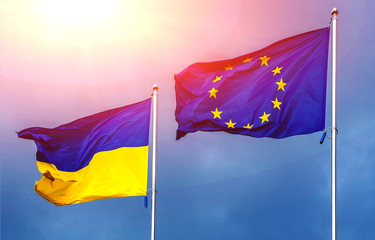 The flag of the European Union and Ukraine, against the background of the sunny sky.