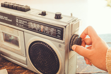 Retro lifestyle - Woman's hand switched and adjusting button cassette player and recorder for...