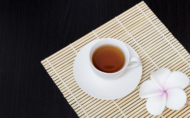 Black coffee is placed in a white cup with a black wooden frame.