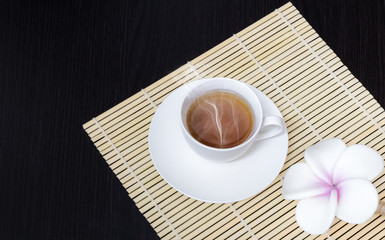 Black coffee is placed in a white cup with a black wooden frame.