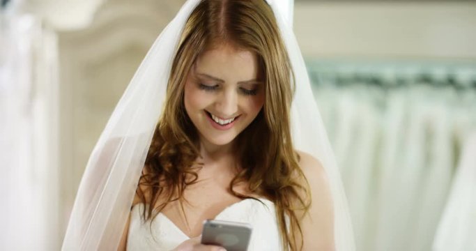4k, Young woman taking self portrait with wedding dress in a bridal shop.