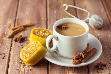 Indian tea masala with spices in white cup, Indian food on wooden table