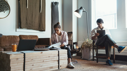 Two people with laptops in small loft office. Man and woman working together