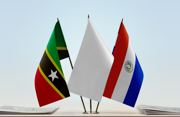 Flags of Saint Kitts and Nevis and Paraguay with a white flag in the middle