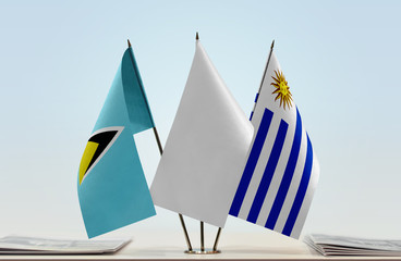 Flags of Saint Lucia and Uruguay with a white flag in the middle