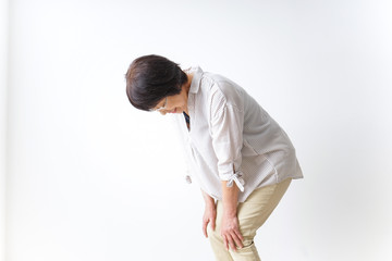 膝の痛みを感じる高齢者の女性