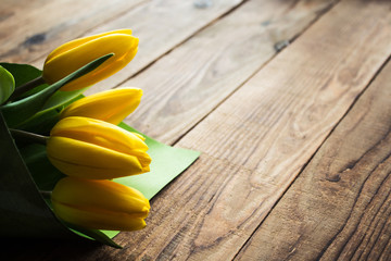 yellow tulips on a wooden background