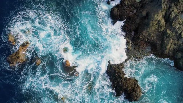 slow motion top down view of waves and clifs