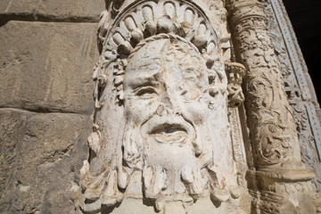 Fototapeta na wymiar broken face sculpture and art relief on exterior facade of ancient building of Museum Santa Cruz, landmark and monument of the Sixteenth century in Toledo city, Spain, Europe 