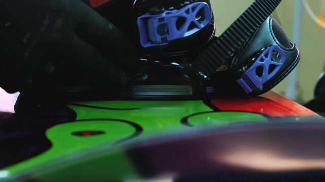 snowboarder fastens the mount to the snowboard. Prepares snowboard for winter to use