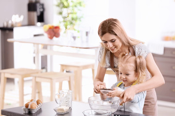 Mother and daughter preparing dough indoors