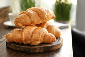 Delicious croissants on wooden board