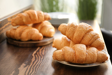 Delicious croissants on wooden table