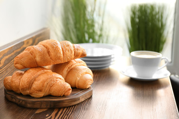 Delicious croissants on wooden board