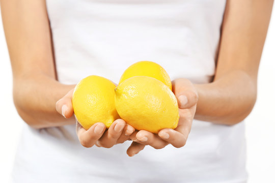 Young woman with ripe lemons, closeup