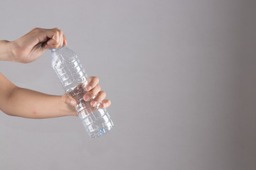 female hand holding and open a plastic bottle.