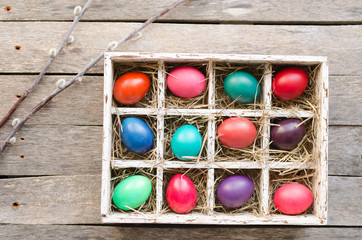 Pussy willows and Easter eggs in a box on old wooden table