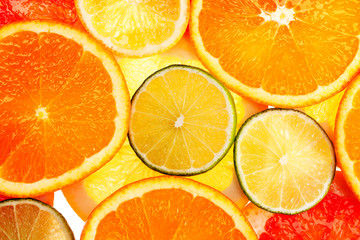 Background of different colored slices of citrus fruits close up