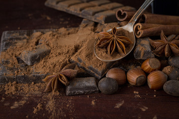 Chocolate, Spices, Spoon with Cocoa on the Wooden Background. Copy space