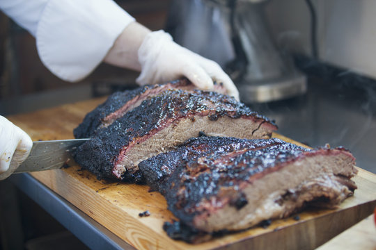 Large piece of smoked brisket meat on a wooden board