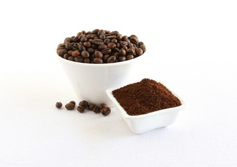 Coffee beans and powder, which is freshly ground, in bowls.