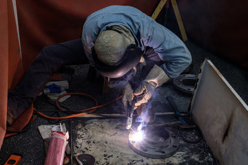 worker with protective mask welding metal