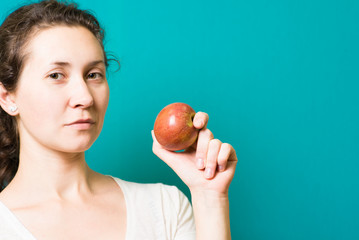 Beautiful close-up portrait of young woman with red apple. Healthy food concept. Skin care and beauty. Vitamins and minerals.