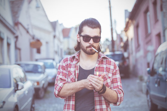 Young man with cigarette posing on the street.