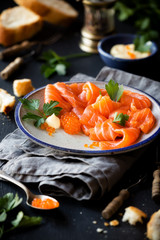 Smoked salmon slices with salted salmon caviar decorated with fresh parsley leaves