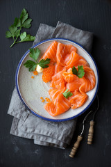 Smoked salmon slices with salted salmon caviar decorated with fresh parsley leaves