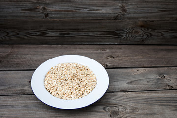 Oatmeal, rolled oats on rustic white wooden background.  Food Concept of healthy eating or vegan food. Healthy breakfast. Copyspace
