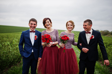 Groomsmen and bridesmaids having fun and posing in blacckcurrant field.