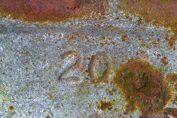Number ‘20’ pressed in  corroded, rusty galvanized iron
