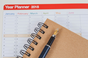 personal organizer or planner with fountain pen on wood table.
