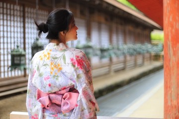 a young Japanese woman in summer kimomo (yukata) with traditional lanterns in a traditional Japanese building
