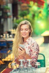 Beautiful woman is  checking phone message in the cafe