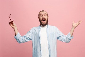 The young attractive man looking suprised isolated on pink