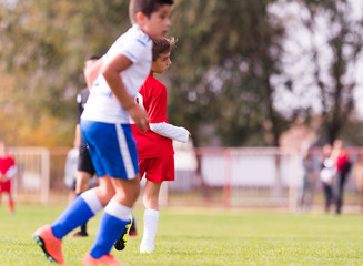 Obraz premium Young children players football match on soccer field