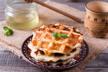 Honey pouring on a fresh waffles. Breakfast with Belgian waffles