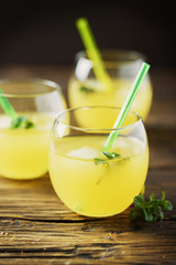 Glasses of orange cocktails with ice and mint