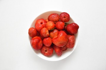 Beautiful and fresh strawberries in a bowl on a white background