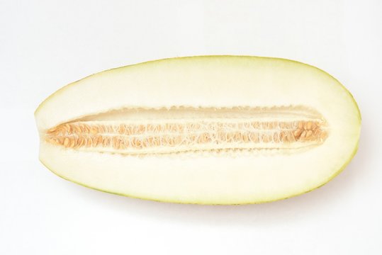 Beautiful and ripe yellow melon on a white background. Cut. With seeds