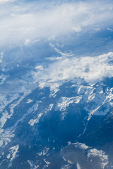 Obraz premium Snowy and cloudy scenic mountains scene from above