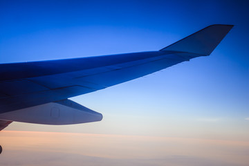 Obraz premium Adventure travel - plane wing and clouds during sunset