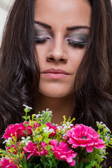 Naklejka premium Attractive young brunette woman holding fresh flowers