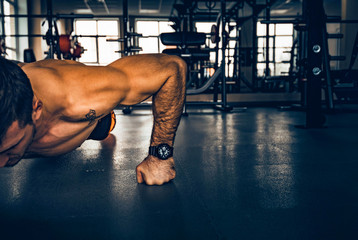 Fitness man performs push ups with naked torso